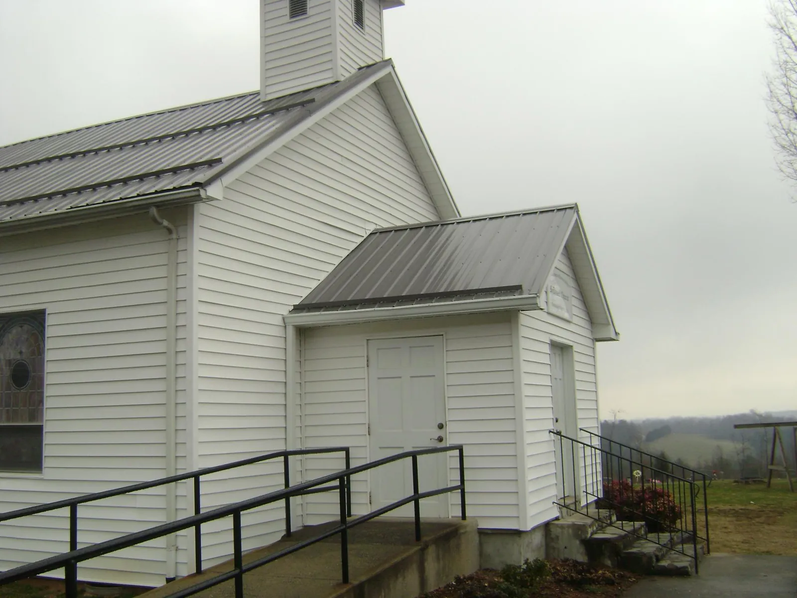 Gray metal roof on a white clapboard church with a steeple in Sanford